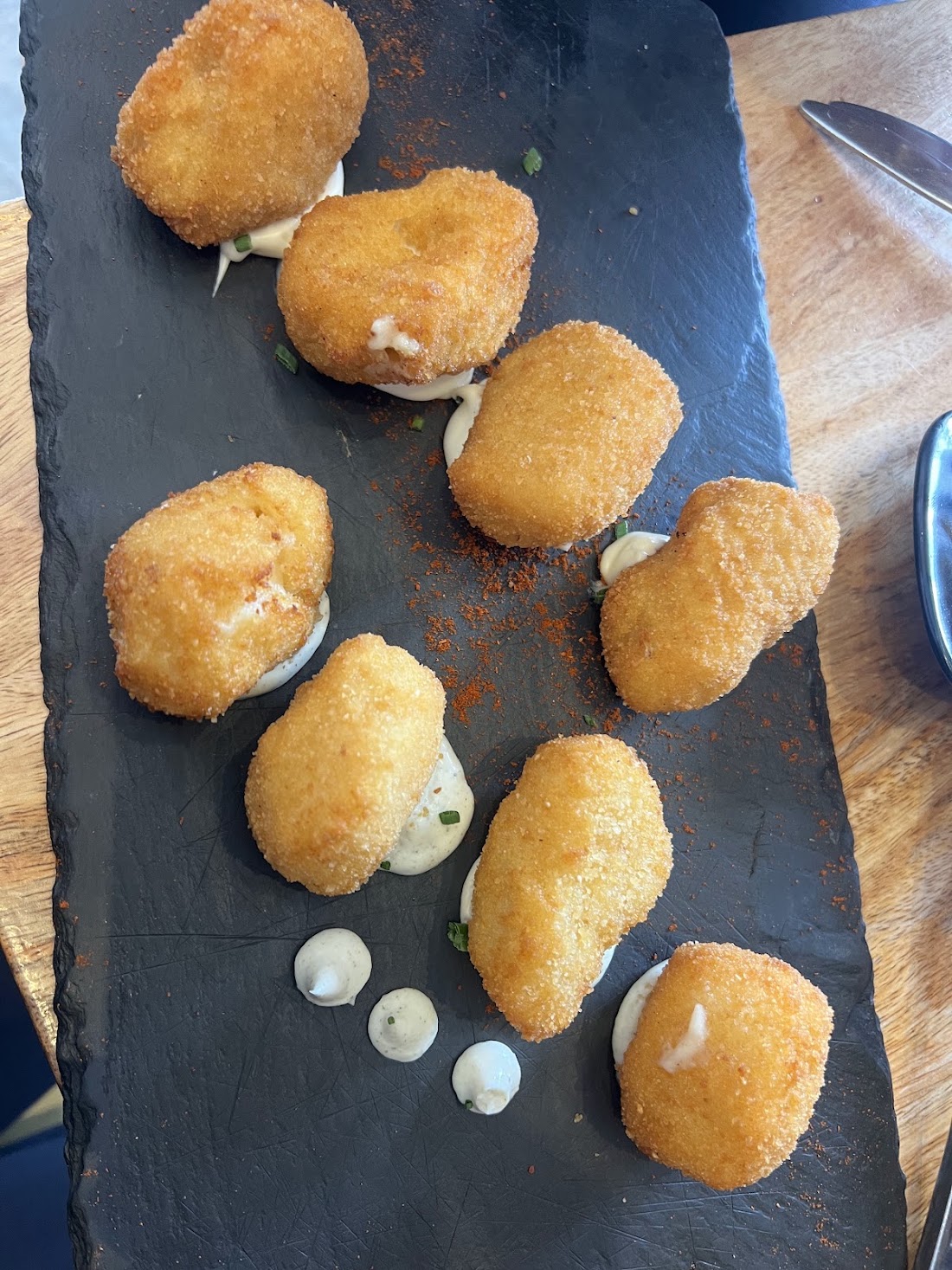 Croquetas caseras servidas en plato negro